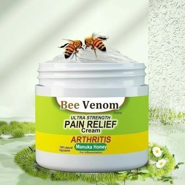 Bee Venom Pain Relief Cream jar with bees on top, grass and flowers in the background